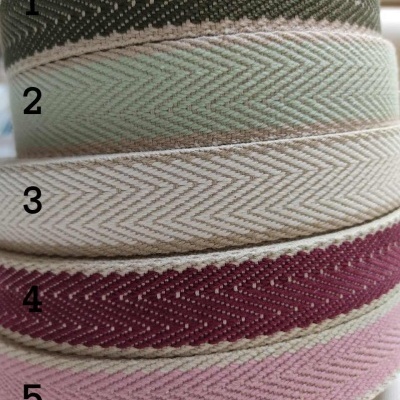 Cinco rolos de fita texturada empilhados com padrão espinha de peixe em várias cores