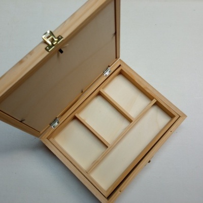 Caixa de madeira clara com fecho metálico aberta