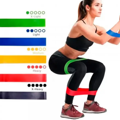 Mulher a fazer agachamento com bandas elásticas de várias cores e indicação de níveis de resistência.