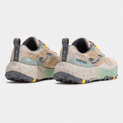 Ténis desportivos bege, cinza, verde e amarelo com sola robusta e marcas visíveis.