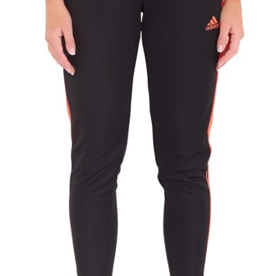 Calças desportivas pretas Adidas com riscas laranja usadas por modelo