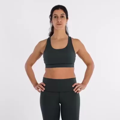 Mulher vestindo conjunto desportivo preto com soutien e leggings, fundo branco