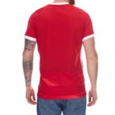 Homem de costas vestindo t-shirt vermelha com detalhes brancos e calças de ganga azuis