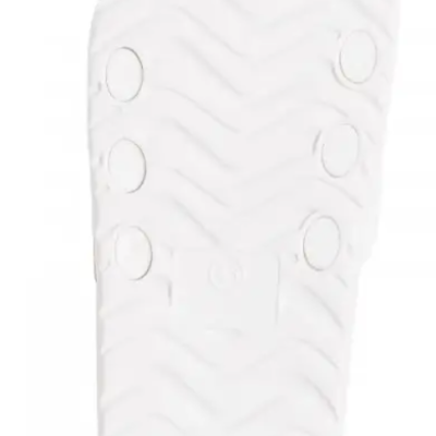 Sola branca de calçado com padrão em zigzag e pontos circulares elevados