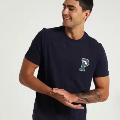 Homem com t-shirt azul escuro com logótipo 'P' verde e branco no peito