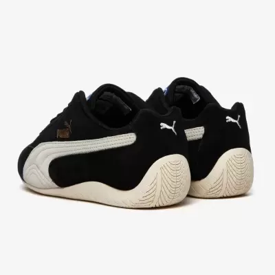 Sapatilhas Puma pretas com detalhes brancos e dourados vistas de trás