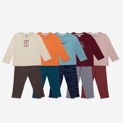 Conjunto de cinco pijamas infantis com camisolas e calças em várias cores e padrões.