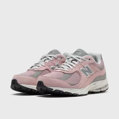 Sapatilhas New Balance rosa e cinza com sola branca e preta