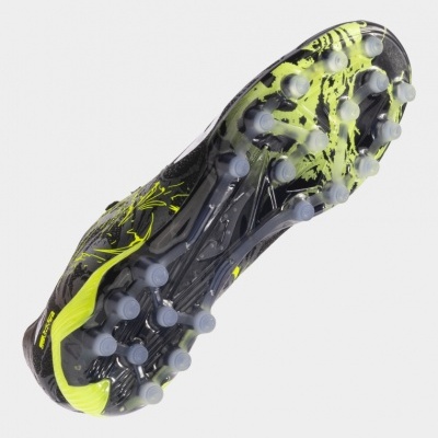 Chuteira preta e amarela vista pela sola com tacos.