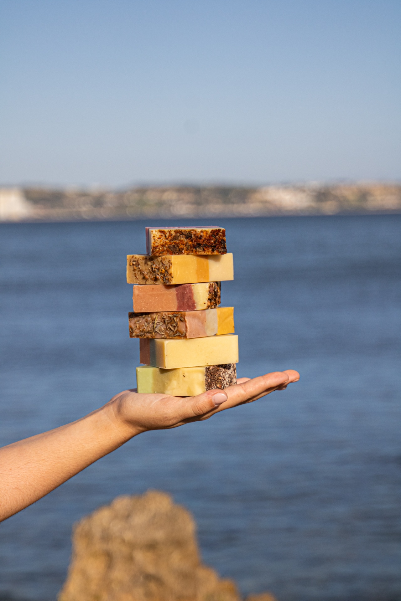 Conjunto 6 Sabonetes naturais (naturais e vegan) Barras de sabão empilhadas em mão com mar ao fundo