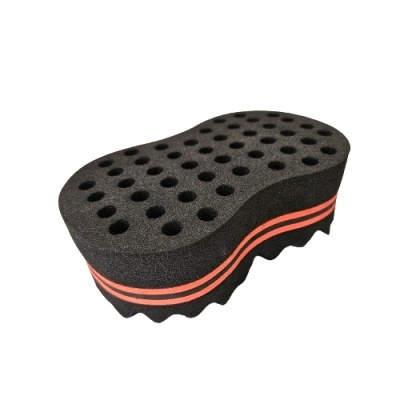 Esponja oval preta com faixa laranja e orifícios na superfície superior