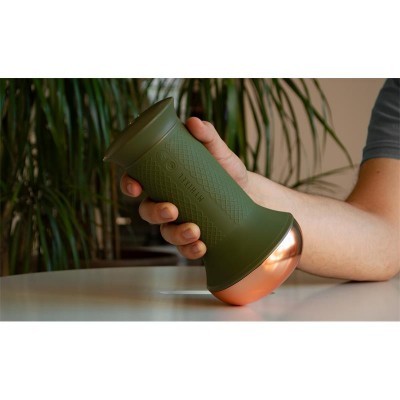 Termómetro digital para cerveja verde com base cobre, segurado por mão, com plantas ao fundo.