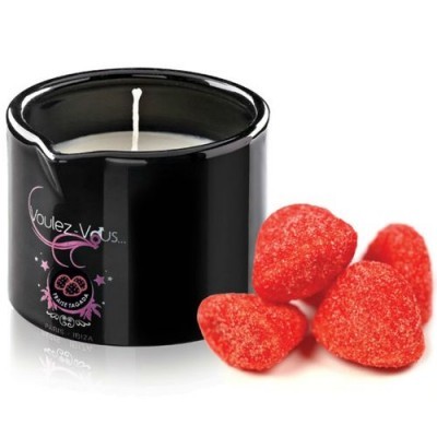 Vela branca em recipiente preto com morangos vermelhos açucarados ao lado
