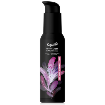Frasco negro com doseador e design de penas lilases e rosa, texto Coquette Vegan Lubes Waterbased Woman Sensitive.