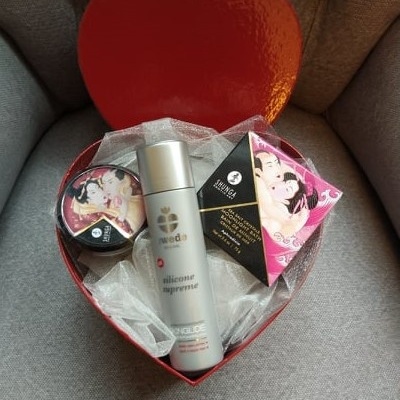 Caixa de presente vermelha em forma de coração com produtos Shunga e frasco prateado silicone supreme