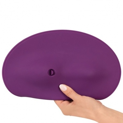 Bolsa ou estojo oval roxo de silicone com fecho de pressão, segurado por uma mão