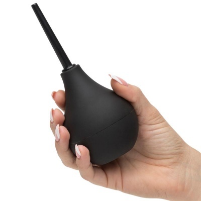 Bulbo de borracha preto segurado por uma mão com unhas brancas