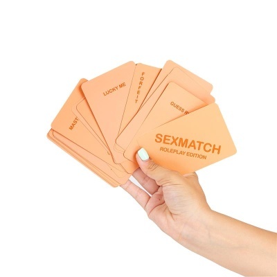 Jogo de cartas SEXMATCH ROLEPLAY EDITION em mãos com texto em vermelho.