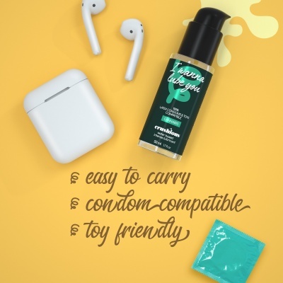 Frasco de creme lubrificante vegano, auriculares brancos e preservativo azul sobre fundo amarelo com texto