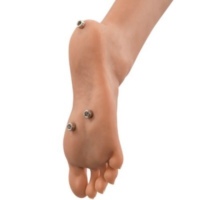 Pé descalço com betões metálicos na sola sobre fundo branco