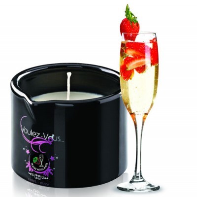 Vela preta com inscrição roxa e taça de champanhe com morangos