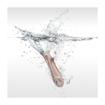 Dispositivo de limpeza facial rosa e branco submerso em água com respingos