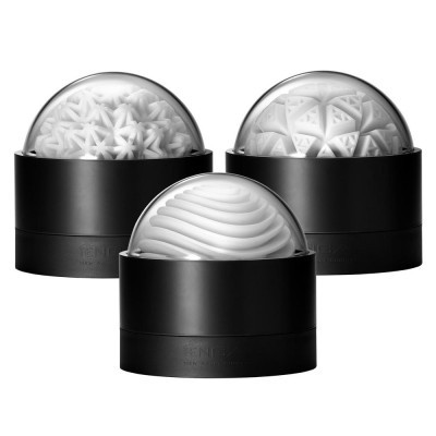 Três objetos decorativos brancos com padrões geométricos em bases pretas cilíndricas