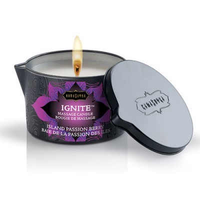 Vela de massagem Ignite Island Passion Berry acesa em recipiente preto com tampa preta ao lado