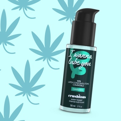 Frasco de lubrificante com cannabis e doseador preto sobre fundo azul com folhas de cânhamo