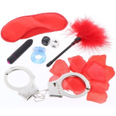 Conjunto de acessórios eróticos com venda vermelha, algemas prateadas, pena vermelha, pétalas, anel azul, vibrador preto, dado preto e branco