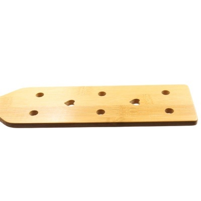 Tábua de cortar de madeira clara com furos redondos e em forma de coração