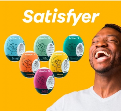 Seis massageadores Satisfyer coloridos com nomes distintos em fundo amarelo e homem sorrindo