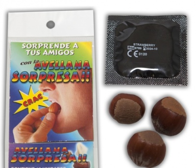 Embalagem colorida em papel, três avelãs e preservativo em embalagem preta