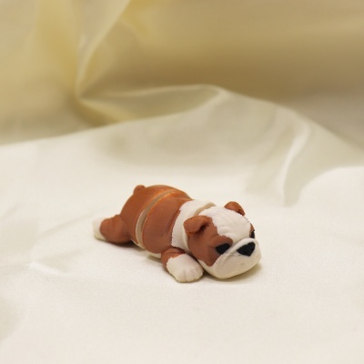 Figura pequena de cão bulldog castanho e branco