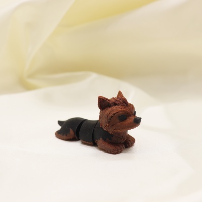 Miniatura de cão castanho e preto sobre tecido claro