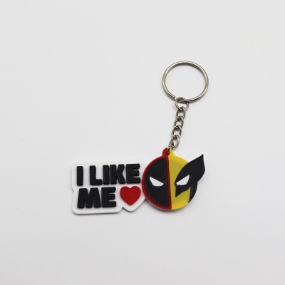 Chaveiro com texto I LIKE ME e figura colorida com olhos brancos.