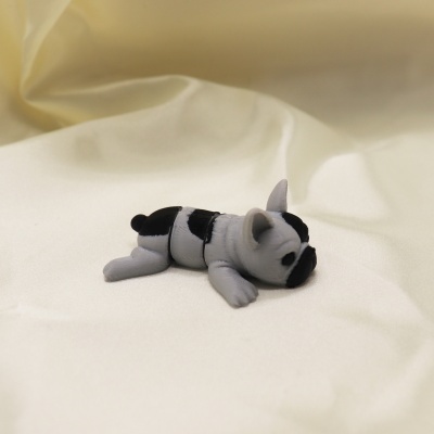 Miniatura de cachorro cinza e preto deitado sobre tecido branco