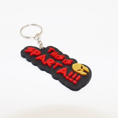 Porta-chaves preto com texto vermelho THIS IS SPARTA e capacete amarelo