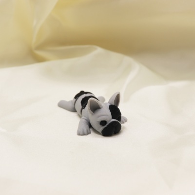 Figura decorativa de cão bulldog cinzento e preto sobre tecido branco