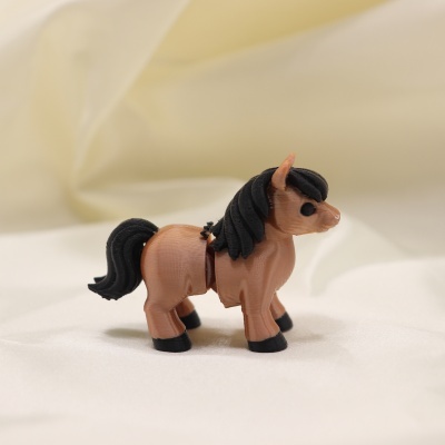Miniatura de cavalo castanho e preto em plástico sobre tecido branco
