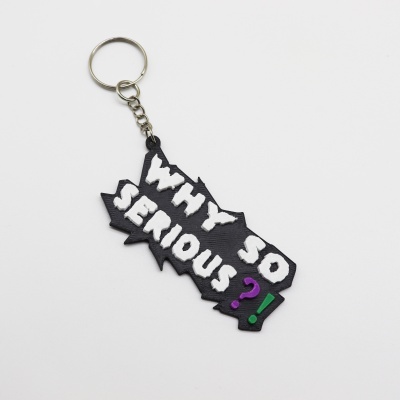 Porta-chaves preto com texto WHY SO SERIOUS em relevo branco.