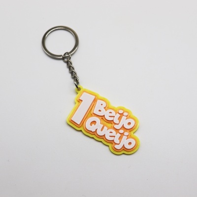 Porta-chaves amarelo com texto 1 Beijo Queijo e argola metálica