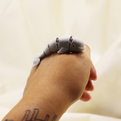 Anel articulado cinzento em forma de lagarto numa mão