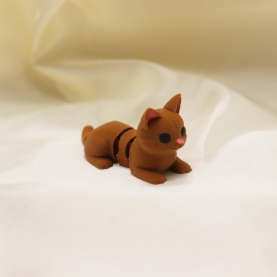 Figura de gato castanho em plástico sobre tecido branco