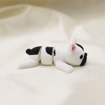 Figura articulada de cão branco e preto sobre tecido branco