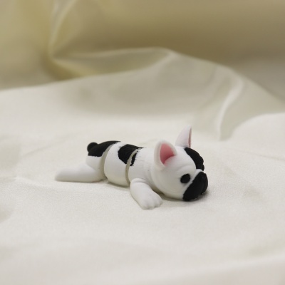Brinquedo de cão articulado preto e branco sobre tecido branco