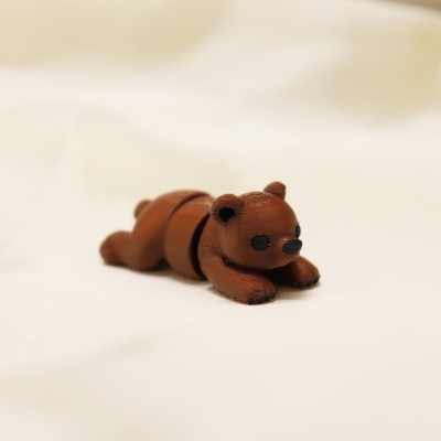 Urso de brinquedo castanho deitado sobre fundo branco