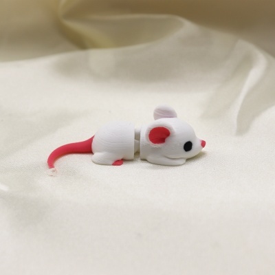 Figura decorativa de rato branco com cauda vermelha sobre tecido branco