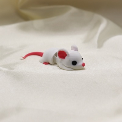 Rato de brinquedo branco e rosa sobre tecido branco
