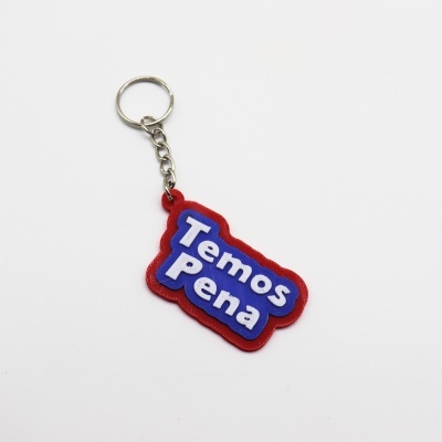 Porta-chaves plástico vermelho e azul com texto Temos Pena em branco.